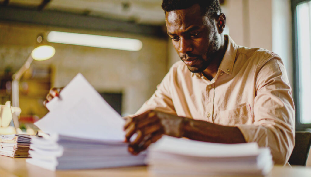 Entrepreneur reviewing financial statements on a laptop while evaluating a small business acquisition